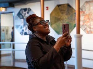 woman taking picture with her phone inside a building during Open House Chicago