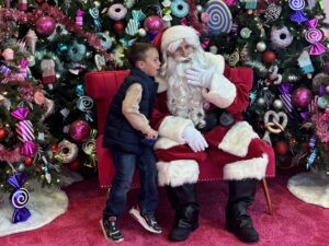 Young child with Santa and christmas trees on pink carpet at Water Tower Place in Chicago