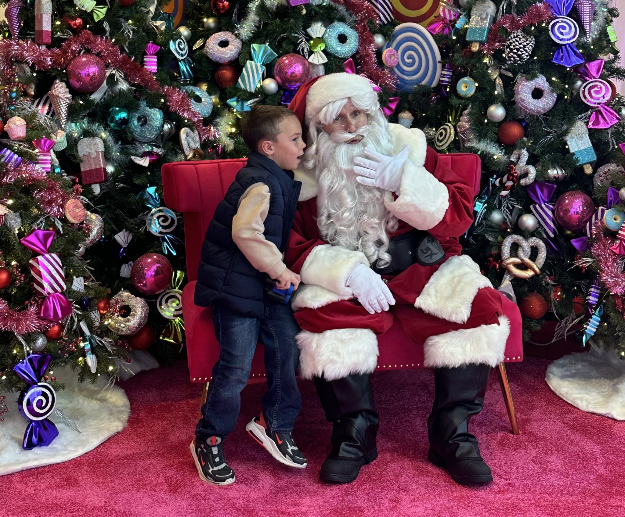 Young child with Santa and christmas trees on pink carpet at Water Tower Place in Chicago
