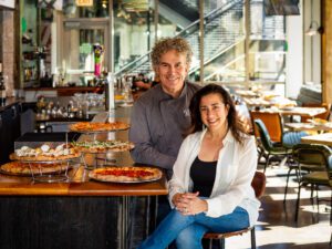 Man and woman in a pizza restaurant with fresh pizza